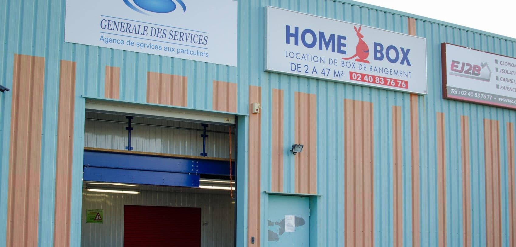 Entrée du centre HOMEBOX Ancenis avec porte ouverte et enseignes visibles.