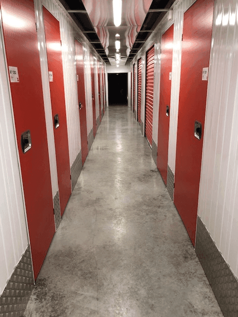 Couloir intérieur avec portes roulantes rouges au centre HOMEBOX Bergerac.