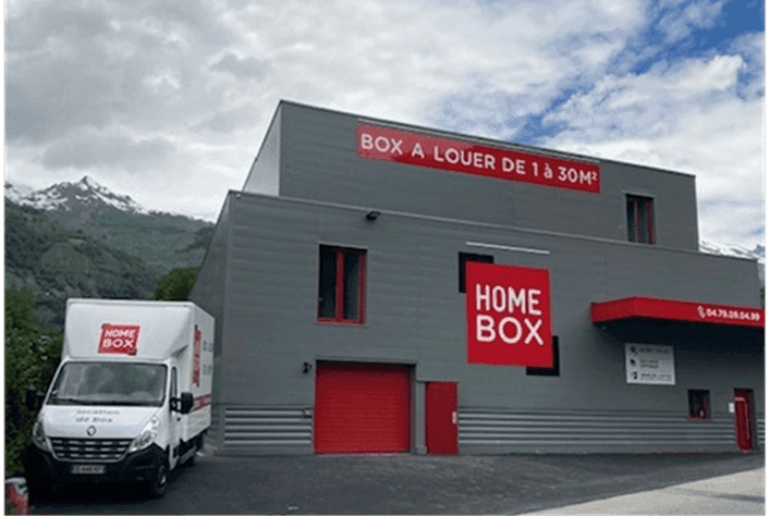 Bâtiment du centre HOMEBOX Bourg-Saint-Maurice avec camion de déménagement garé devant l’entrée.