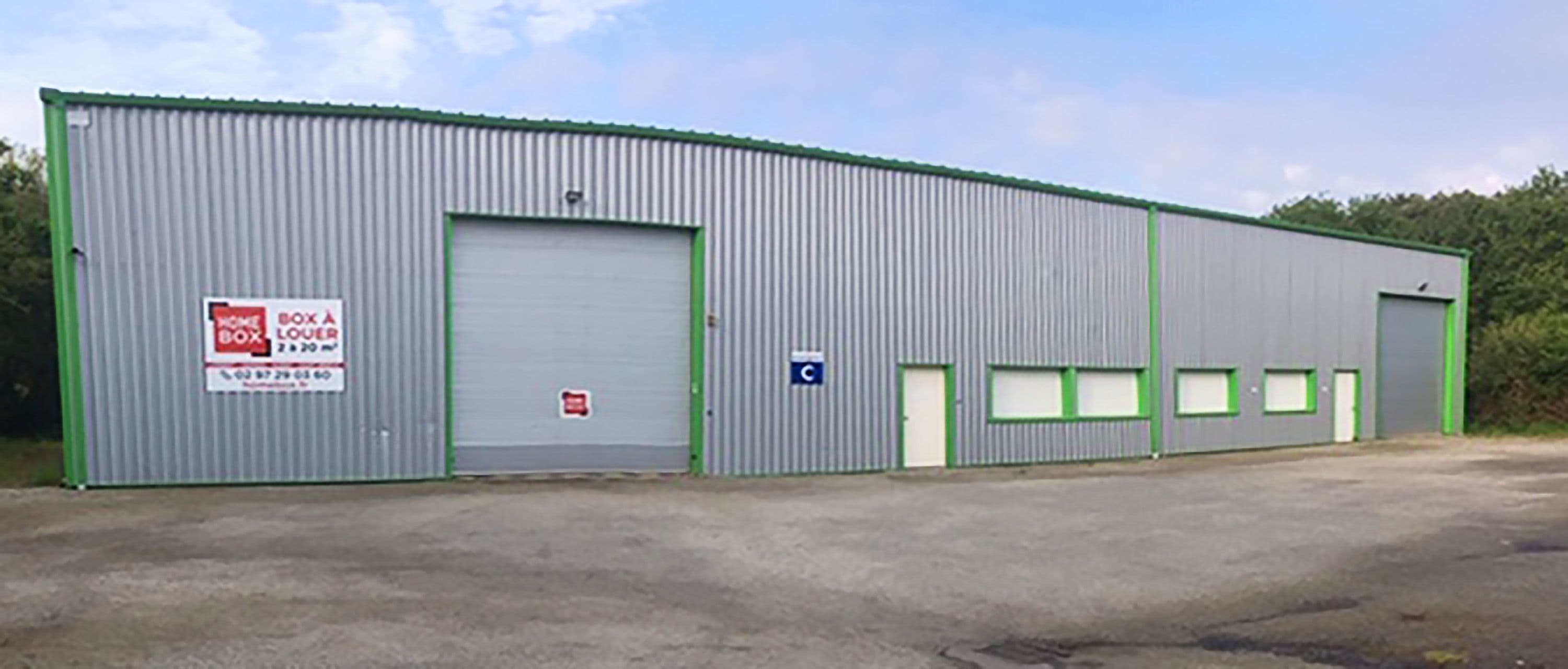 Vue latérale du bâtiment principal du centre HOMEBOX Auray avec portes et enseignes.