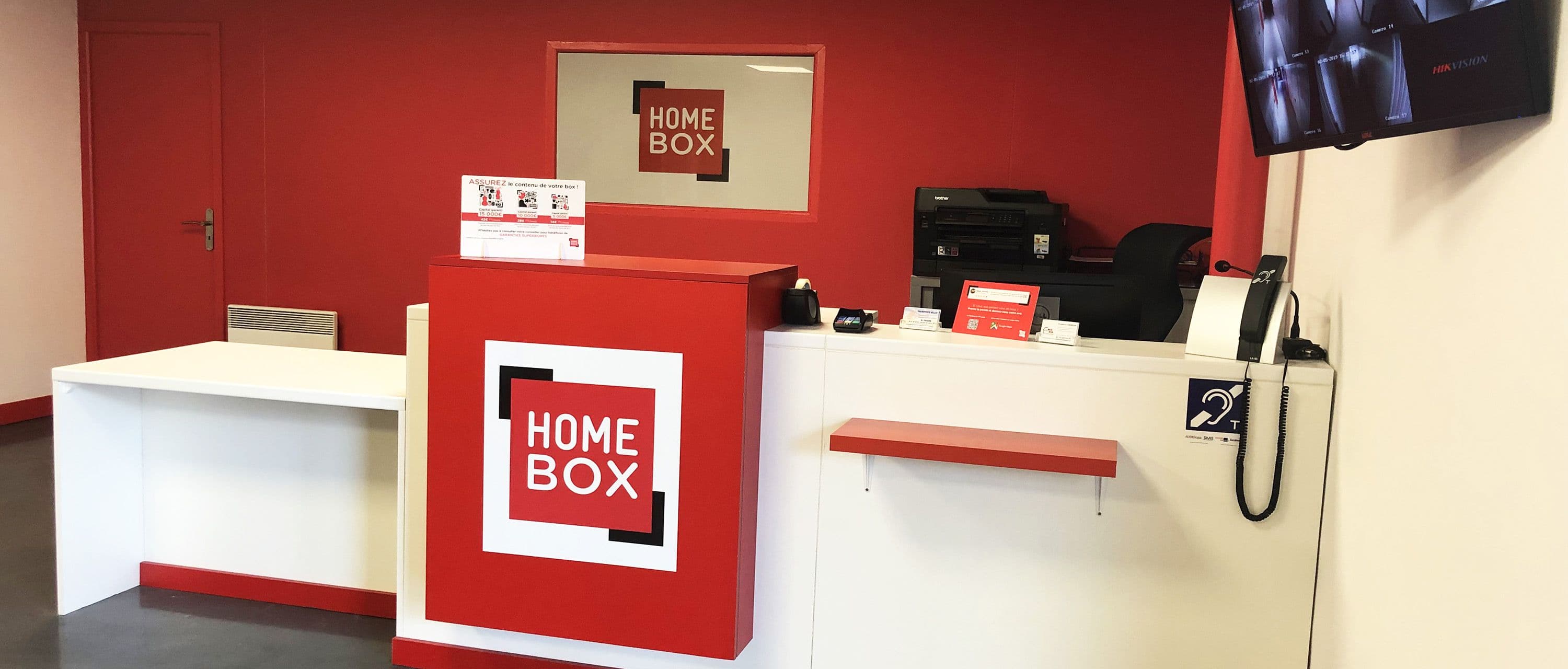 Accueil avec comptoir rouge et blanc au centre HOMEBOX Dreux à Vernouillet.