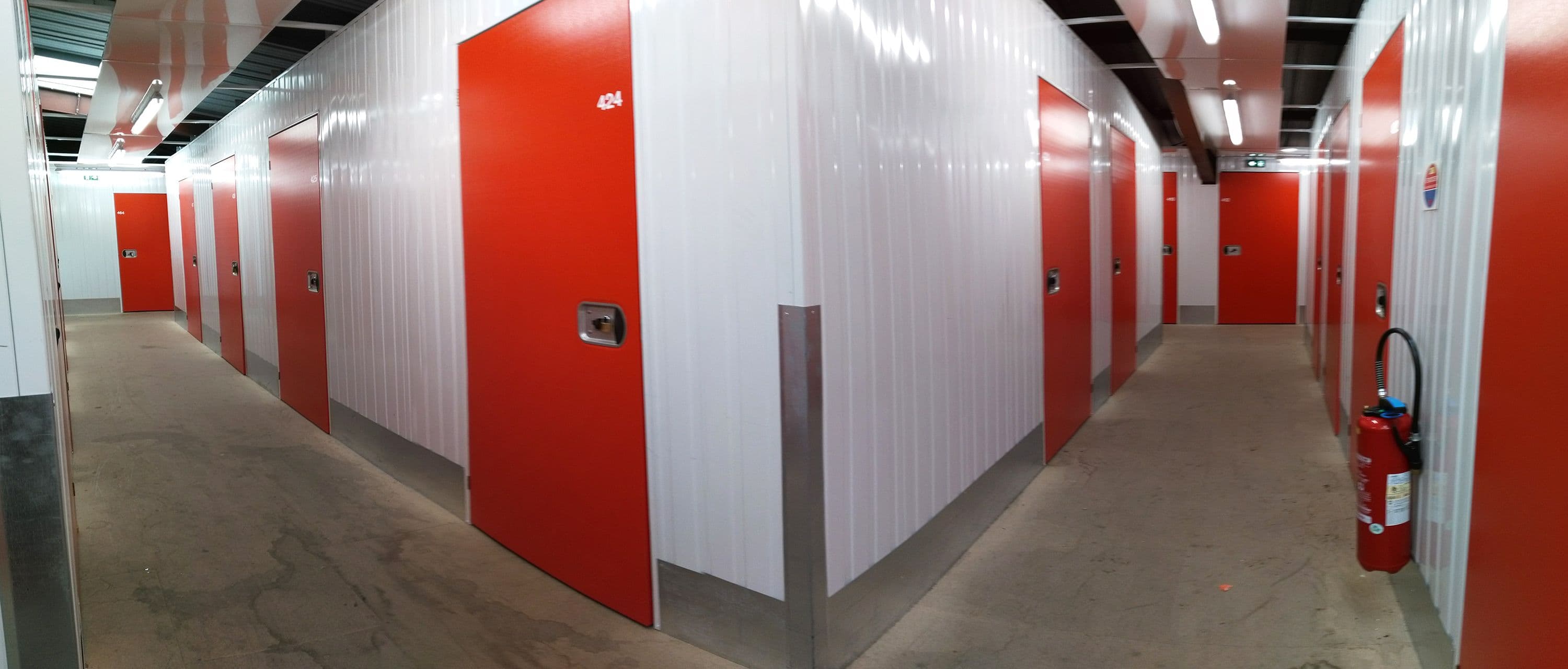 Couloir intérieur avec portes roulantes rouges au centre HOMEBOX Clermont-Ferrand.