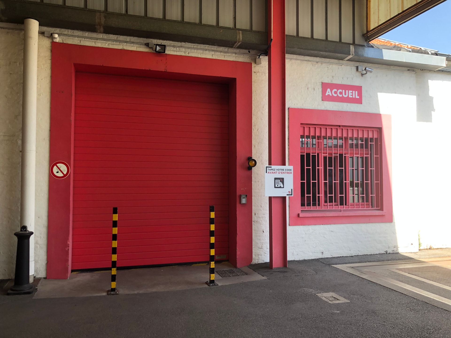 Entrée du centre HOMEBOX Amiens, rue de Sully, avec porte sectionnelle rouge et guichet d’accueil.