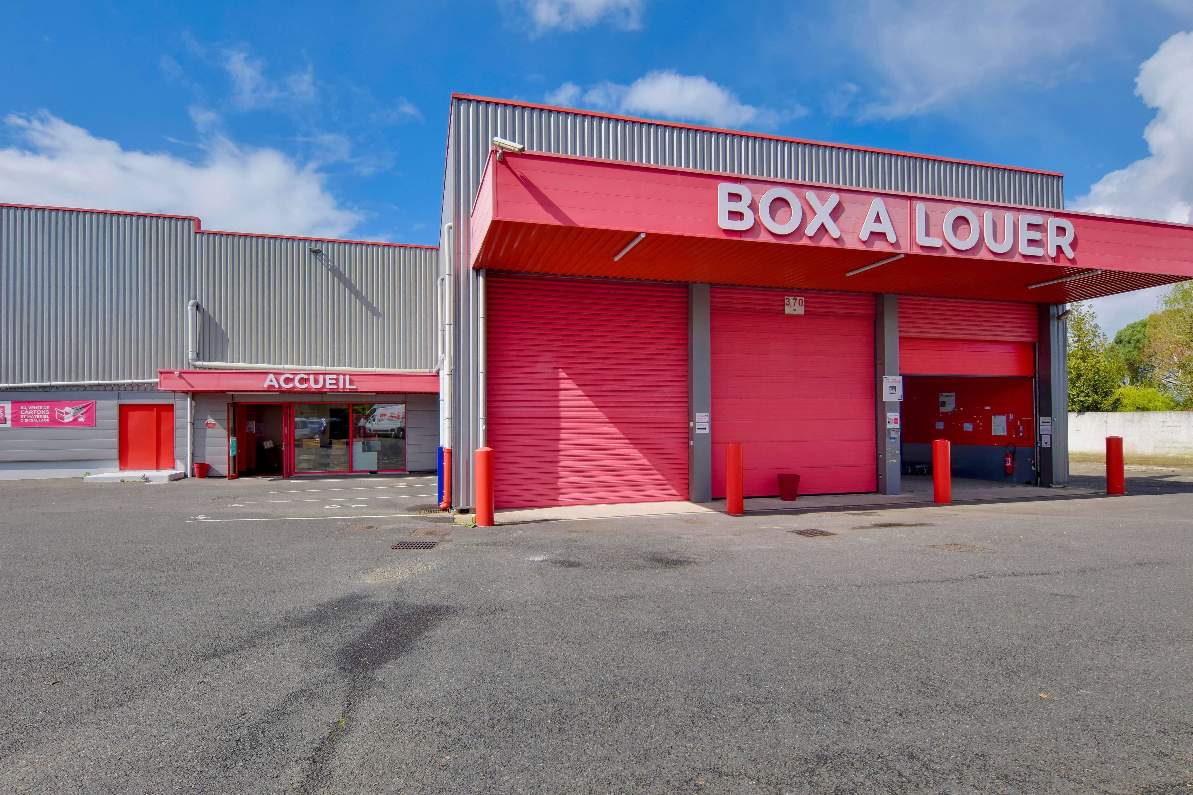 Façade du centre HOMEBOX avec grands box rouges à louer, situé au 2 Rue du Petit Rocher