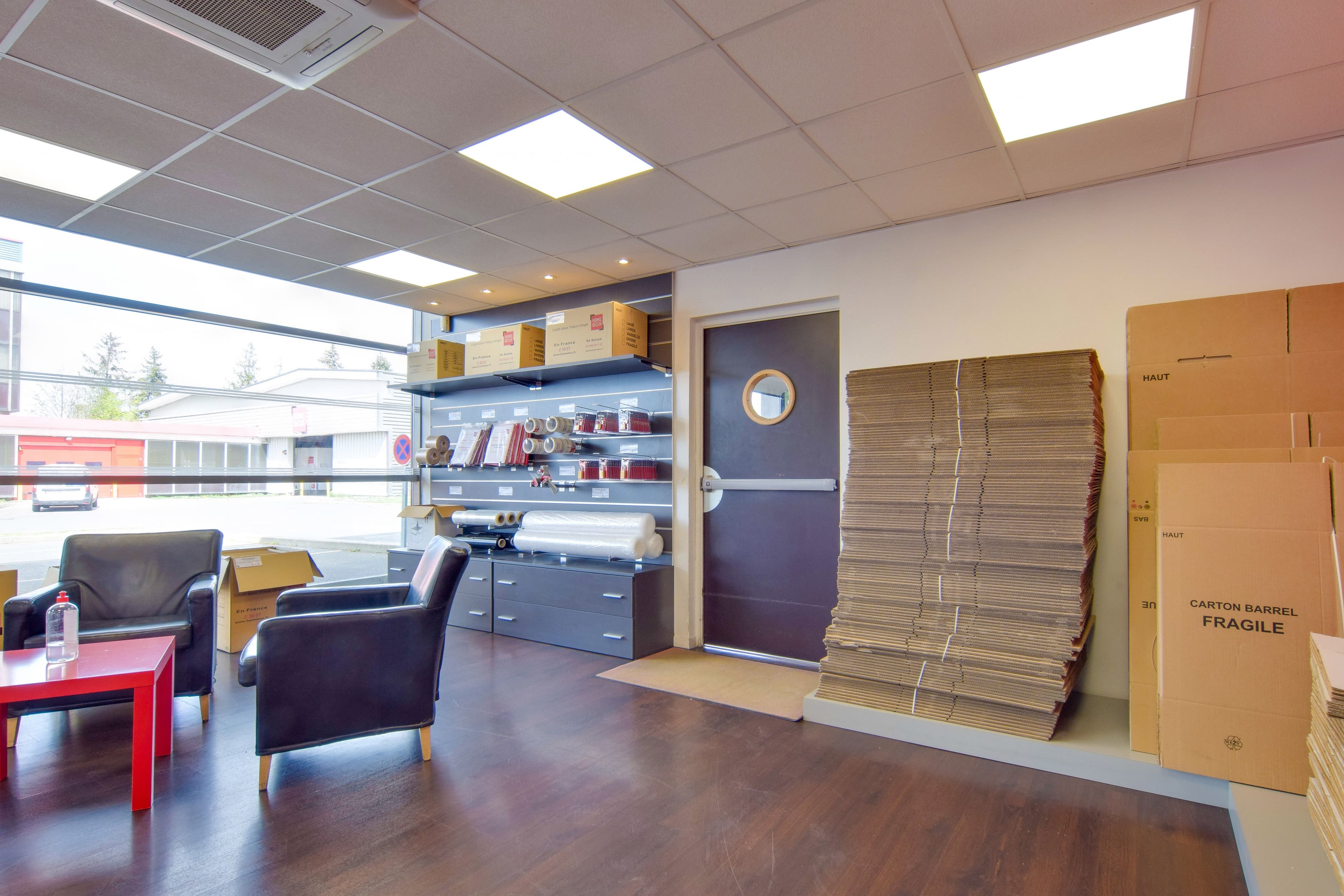 Salle d’accueil avec fauteuils et fournitures exposées au centre HOMEBOX Évry-Courcouronnes.