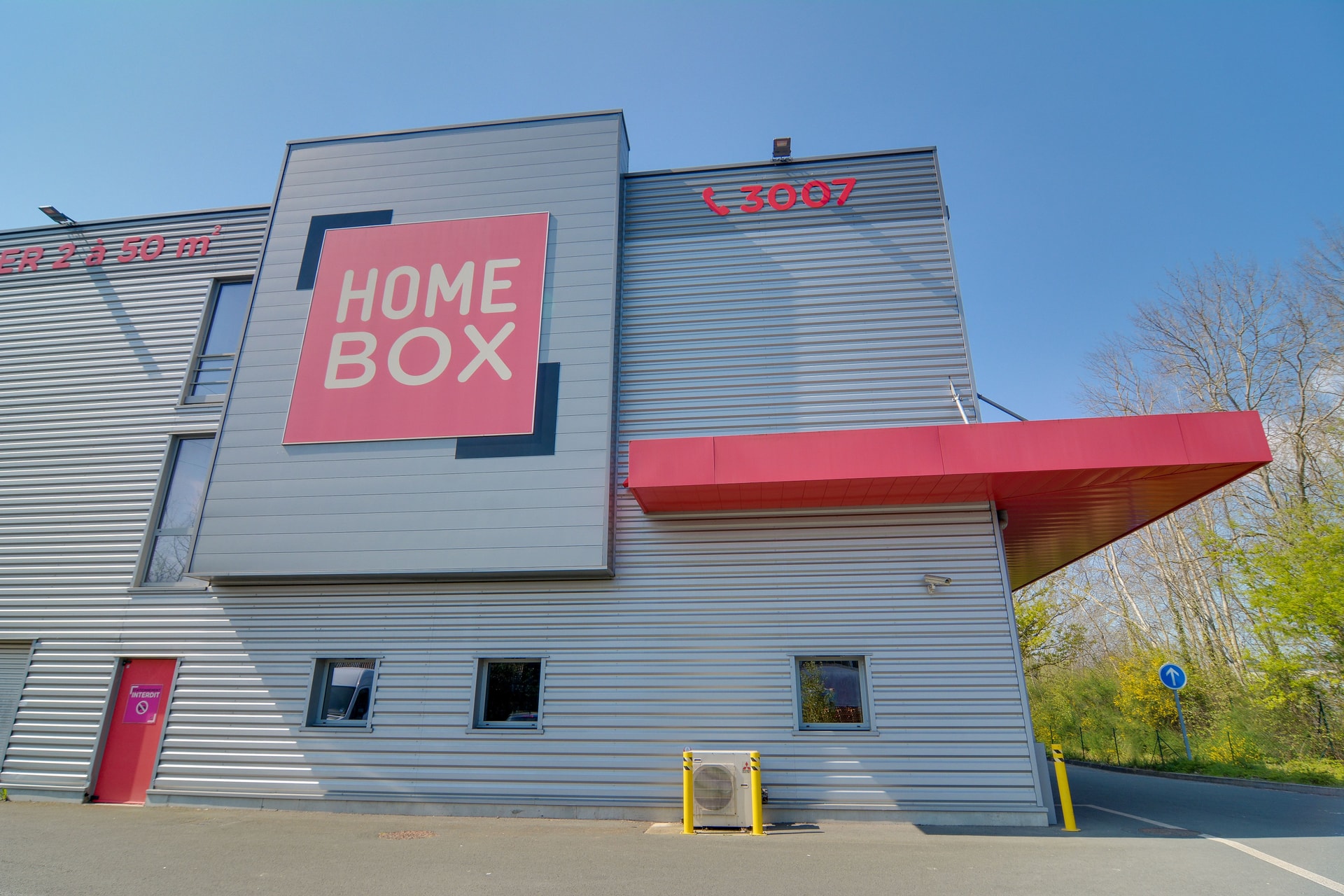Façade du centre HOMEBOX Angers, boulevard de l’Industrie à Écouflant, bâtiment gris avec logo rouge et noir.