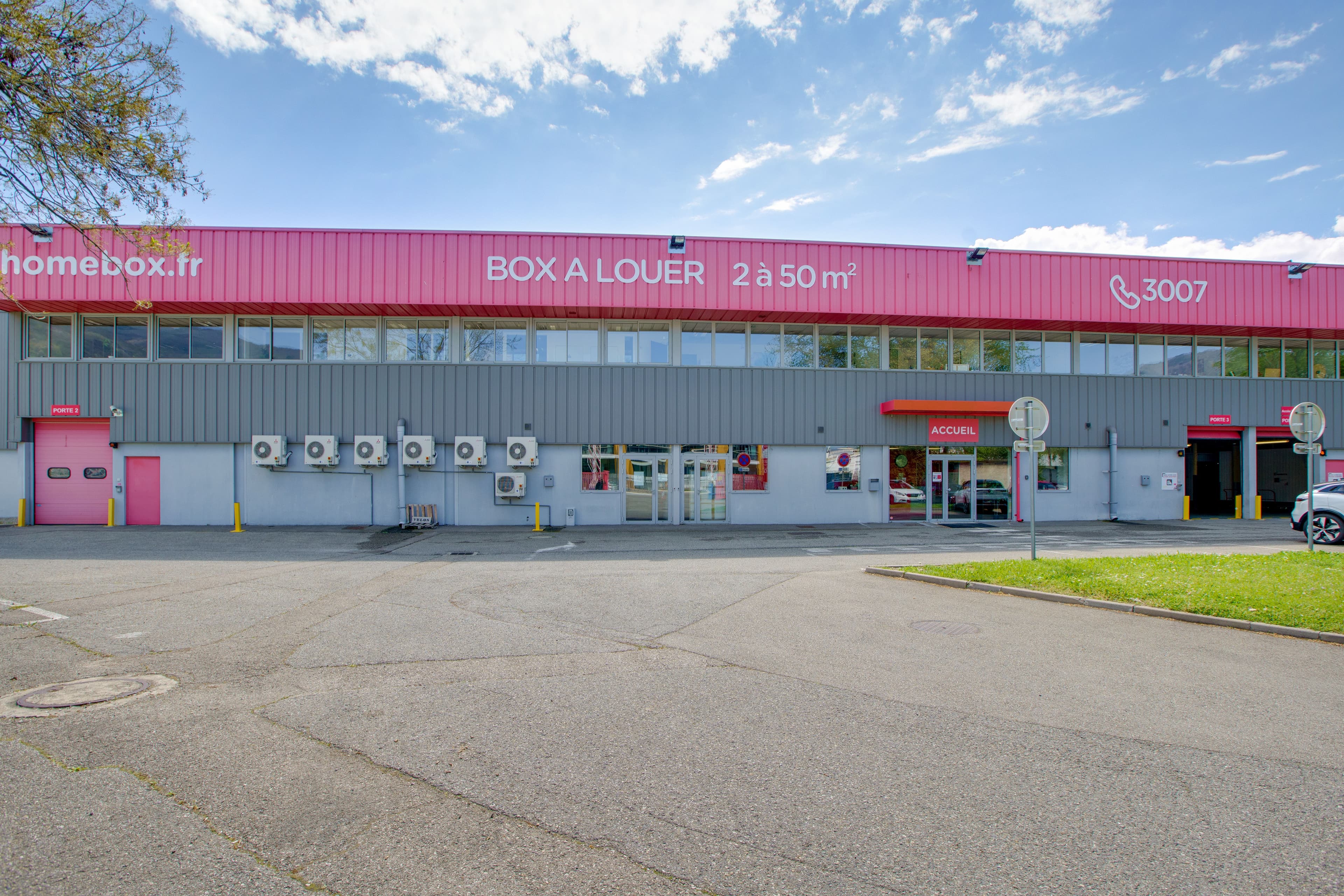 Vue extérieure du centre HOMEBOX Grenoble, 25 rue du Moucherotte, avec parking et enseigne HOMEBOX.