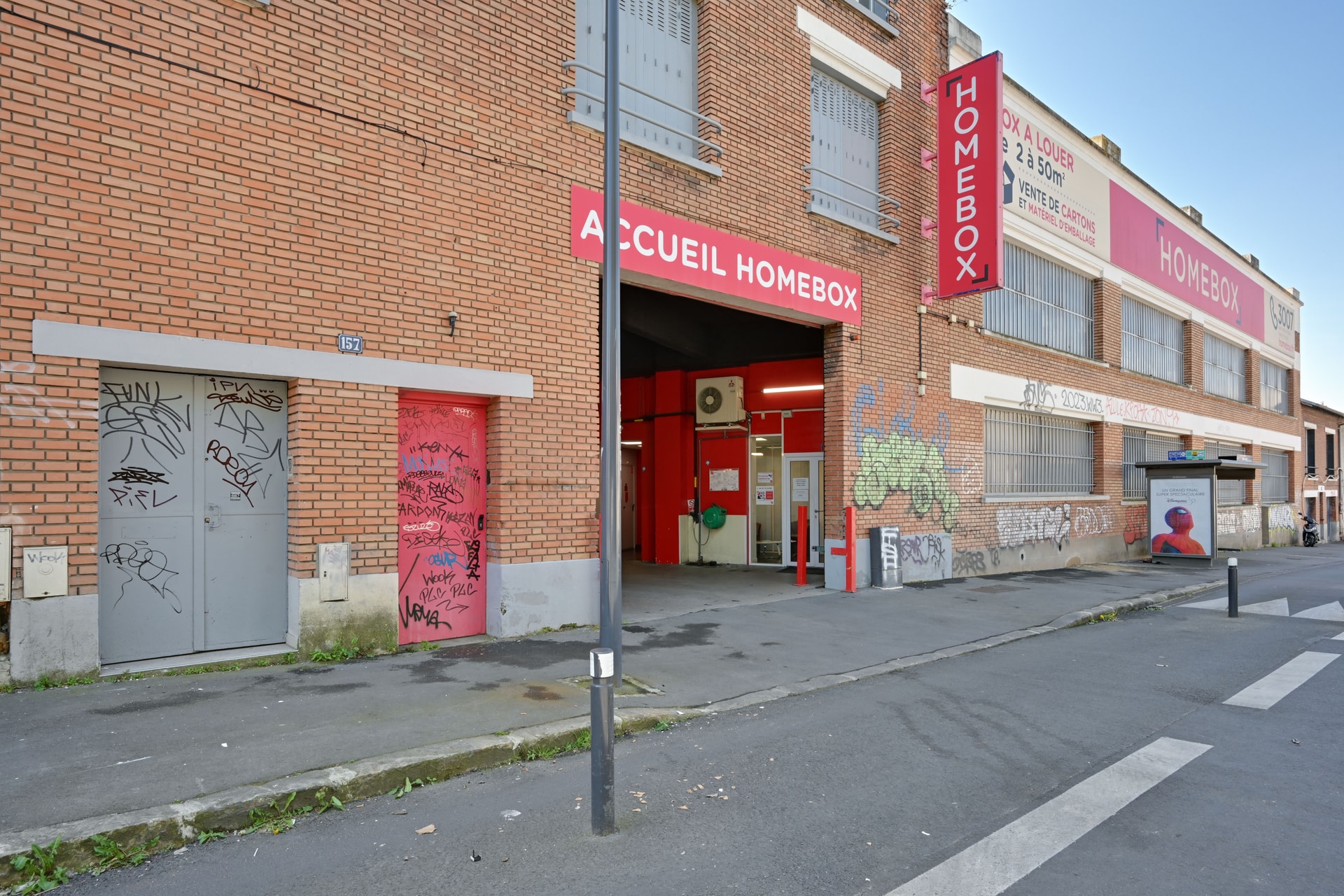 Façade en briques rouges avec enseigne Accueil HOMEBOX et porche d'entrée, HOMEBOX Montreuil, 157 boulevard de Chanzy à Montreuil