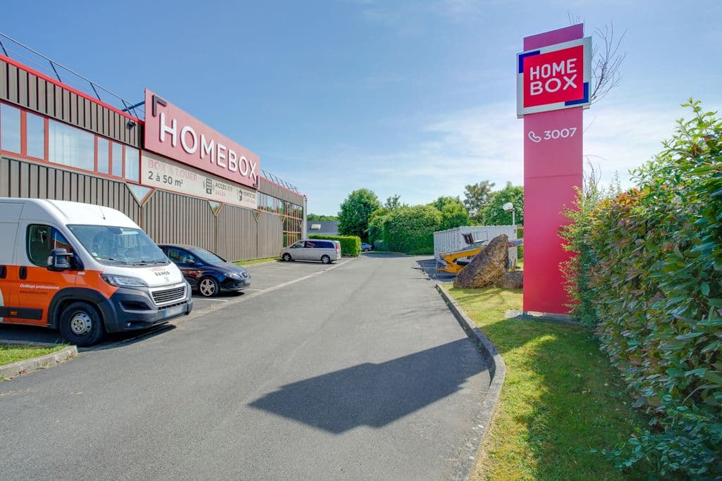 Entrée du centre HOMEBOX Collégien avec totem signalétique et parking.