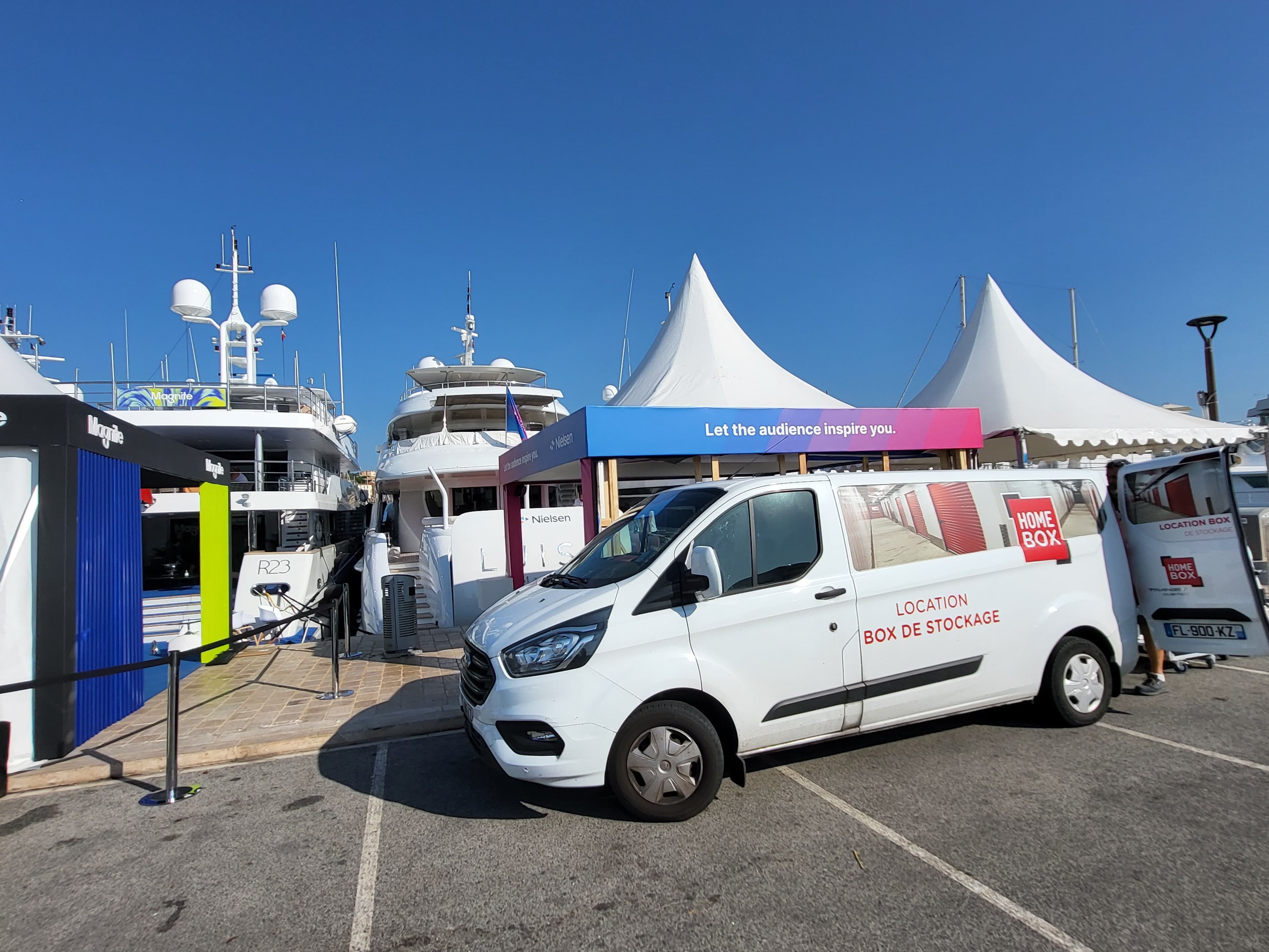 Camionnette HOMEBOX garée devant des tentes d’événement au port de Cannes La Bocca.