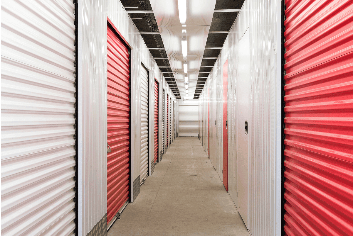 Couloir de box de stockage du centre HOMEBOX Ajaccio-Centre avec portes roulantes rouges et blanches.