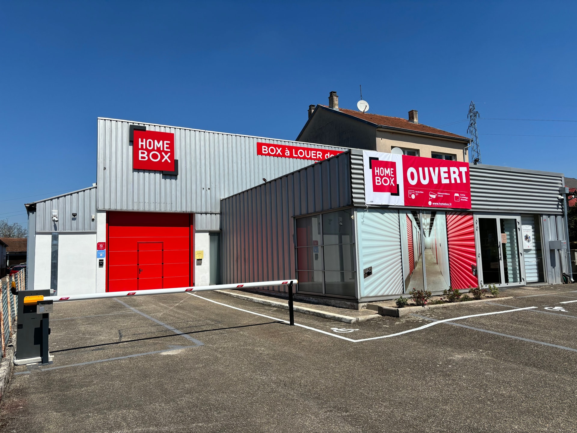 Façade grise avec enseignes rouges HOMEBOX et parking sous ciel bleu, HOMEBOX Morsbach, 105 Route Nationale à Morsbach