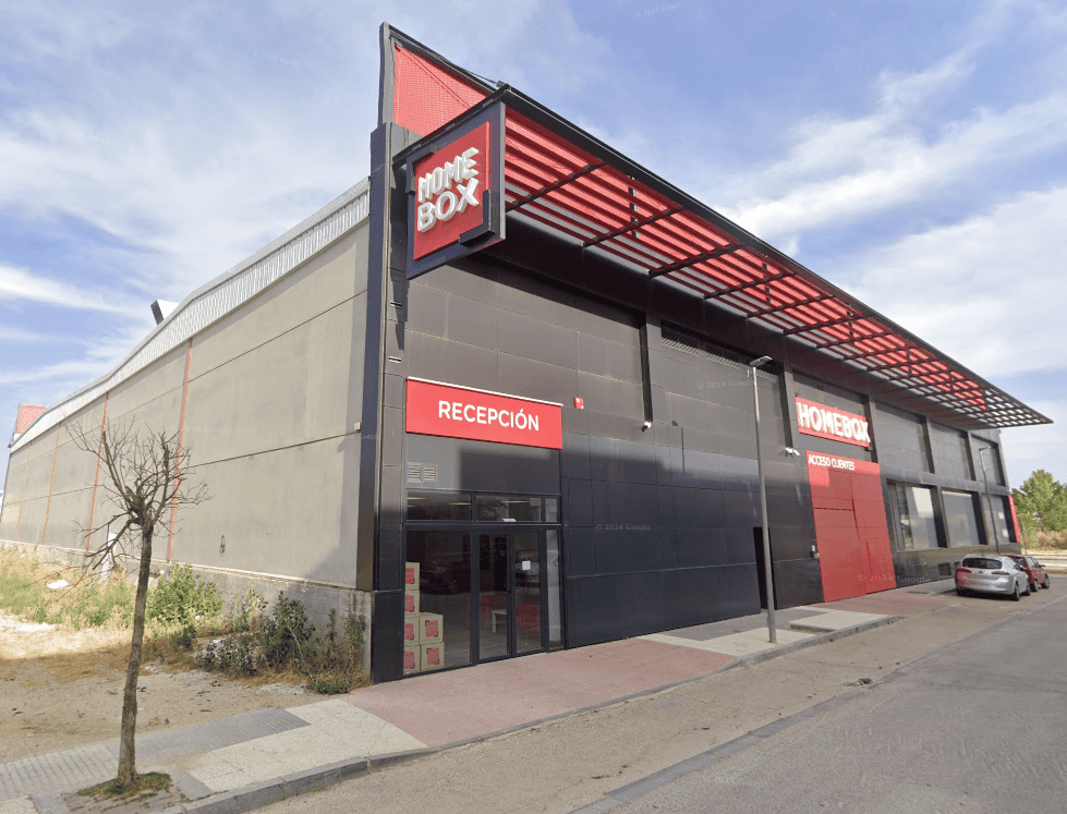 Grey warehouse facade with red HOMEBOX sign and recepción entrance at HOMEBOX Sevilla Aljarafe, Avenida de Europa núm. 162, Sevilla