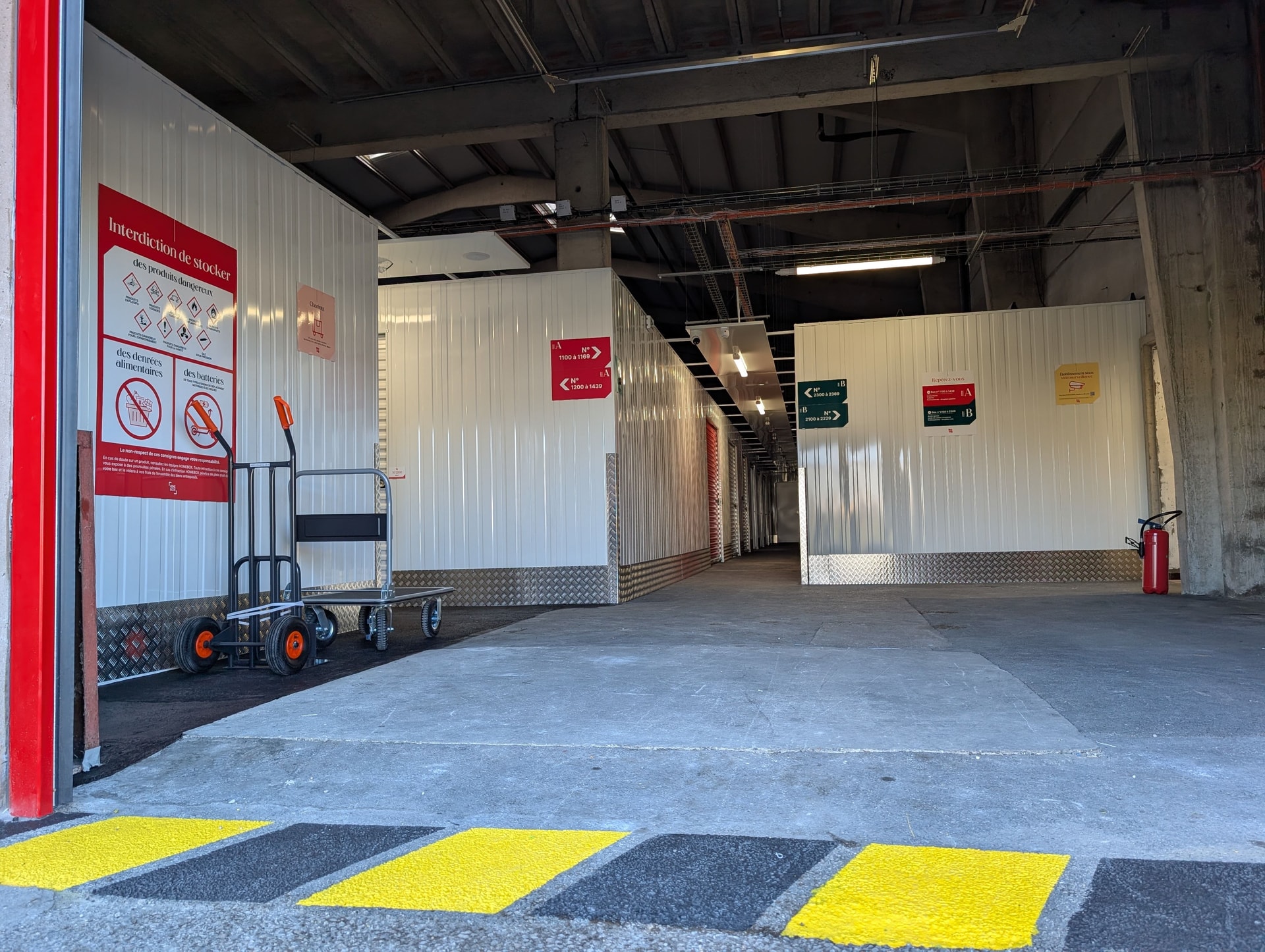 Hall d'entrée intérieur avec chariot de manutention, signalétique et consignes de sécurité du centre HOMEBOX Dunkerque