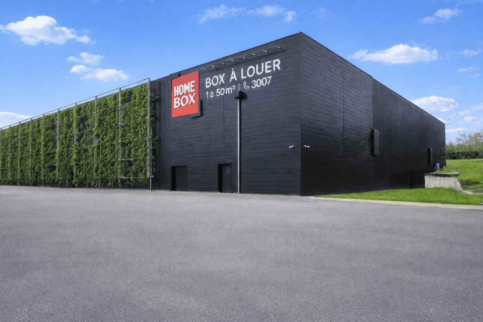 Black warehouse with green vegetal wall and Box à louer banner under blue sky at HOMEBOX Nancy, 8-10 allée Erik Satie, Vandœuvre-lès-Nancy